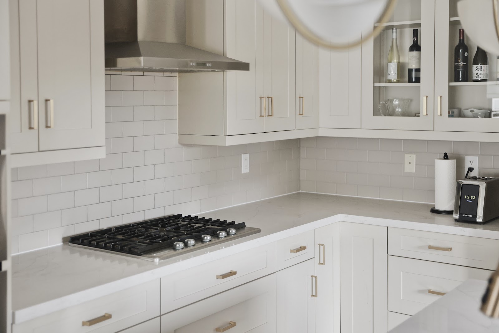 Renovated kitchen with cream shaker cabinets, quartz countertops and brass hardware